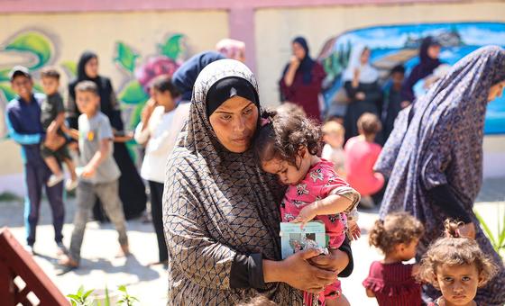 Una mujer sostiene a su hija mientras esperan durante una revisión nutricional en una clínica apoyada por UNICEF en la Franja de Gaza.